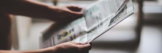 Krant in handen van persoon